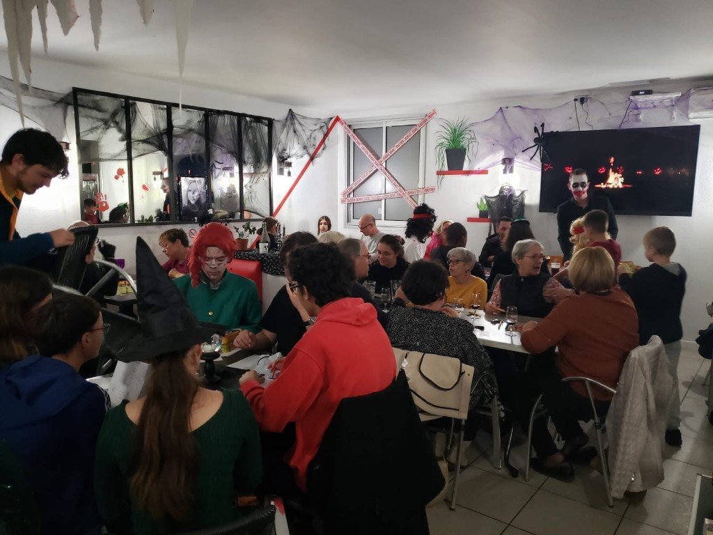 Intérieur du bar Le Bruit des Glaçons lors d’une soirée à thème Halloween, clients en costume.