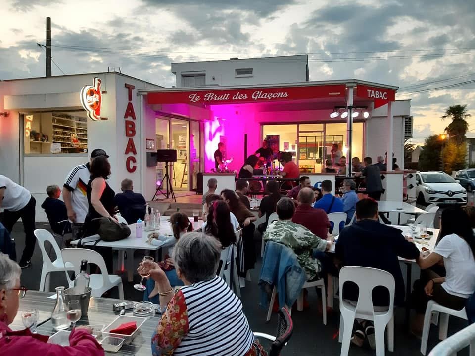 Terrasse animée du soir au Bruit des Glaçons, concert et ambiance conviviale.